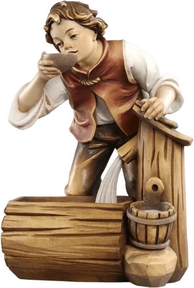 Hand-carved wooden figure of boy drinking from bowl beside a rustic well, hand-painted