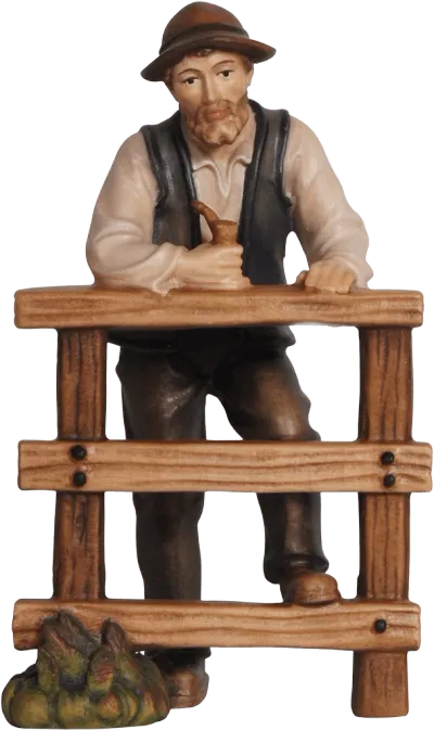 Hand-carved wooden shepherd figure leaning on a fence, painted in natural colors
