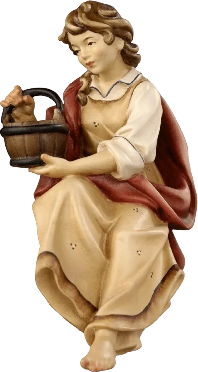 Hand-carved wooden shepherdess sitting at the well holding a basket, hand-painted in natural colors